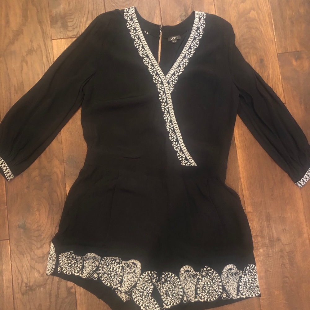 Black short romper with white embroidery.